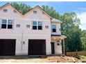 New construction two-story townhome with two-car garage and covered front porch in a wooded, suburban neighborhood at 57 Calluna Dr, Clayton, NC 27520