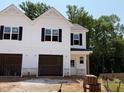 New two-story home featuring white siding, black shutters, an attached garage, and traditional architectural detailing at 57 Calluna Dr, Clayton, NC 27520