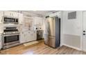 Well-lit kitchen featuring stainless steel appliances, subway tile backsplash, and wood floors at 7708 Foxwood Dr, Raleigh, NC 27615
