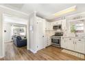 Bright kitchen featuring white cabinets, stainless steel appliances, and hardwood floors at 7708 Foxwood Dr, Raleigh, NC 27615