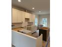 Bright kitchen space with white cabinets and modern farmhouse sink at 801 N Elm St, Durham, NC 27701