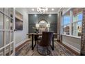 Sophisticated home office with wainscoting, natural light, decorative rug, and elegant furnishings at 937 Thimbleweed Way, Wake Forest, NC 27587