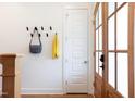 Entryway with wood floors, coat rack, and a glimpse of the front door with sidelight windows at 1008 North St, Durham, NC 27701