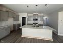 Bright, modern kitchen with gray cabinets, a large island with a sink, and pendant lighting at 118 Fairwinds Drive Dr, Lillington, NC 27546