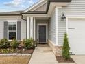 Inviting front entrance with well-maintained landscaping and a modern light fixture at 1207 Bluewater Way, Durham, NC 27703