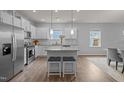 Bright open kitchen with island seating, stainless steel appliances, and views of the dining area at 1207 Bluewater Way, Durham, NC 27703