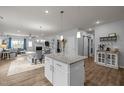 Open-concept living space with kitchen island, dining area, and cozy living room with fireplace at 1207 Bluewater Way, Durham, NC 27703
