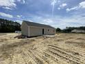 The home features neutral colored siding, a gray roof, and a concrete patio in the backyard at 129 Grace Pond Ave, Benson, NC 27504