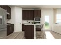 Bright kitchen features a kitchen island with counter seating and stainless steel appliances at 1300 Hazelnut Ridge Ln, Knightdale, NC 27545