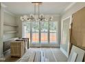 Bright dining room featuring a modern light fixture, large windows, and built-in cabinetry at 1309 Sanctuary Pond Dr, Raleigh, NC 27603