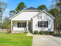Welcoming single-story home featuring neat landscaping, a covered front porch, and a sunny curb appeal at 1406 Summerville Mamers Rd, Lillington, NC 27546