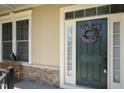 Elegant front door with wreath, sidelight, and nearby bench seating on a covered porch at 150 Lystra Ridge Rd, Chapel Hill, NC 27517