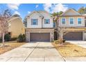 Two-story townhome with a brick and siding facade, two-car garage, and concrete driveway at 154 Alamosa Pl, Cary, NC 27519
