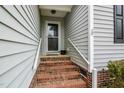 Inviting front entrance with brick steps, white railings, and light gray siding at 1808 W Cotton Gin Dr, Clayton, NC 27527