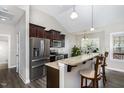Kitchen with stainless steel appliances, dark brown cabinets, and a breakfast bar with seating at 191 W Cultivator Way, Clayton, NC 27520