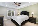 Bedroom with tray ceiling, neutral walls, carpeted floor, and large window at 191 W Cultivator Way, Clayton, NC 27520