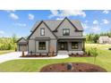 Beautiful two-story home with gray siding, black trim, and a well-manicured lawn at 20 Serenity Woods Trl, Franklinton, NC 27525