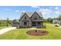 Charming two-story home with gray siding, black trim, and a manicured lawn in a lovely neighborhood at 20 Serenity Woods Trl, Franklinton, NC 27525