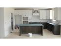 The kitchen features custom white cabinets, contrasting lower cabinets, and a kitchen island at 20 Serenity Woods Trl, Franklinton, NC 27525
