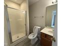 Cozy bathroom featuring a walk-in shower, toilet, sink and vanity with wood cabinets and tiled floor at 202 Allen St # A/B, Creedmoor, NC 27522
