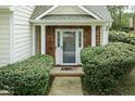 Covered front porch with wood accents and manicured bushes framing the entryway at 206 Newberry Ln, Durham, NC 27703
