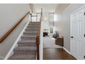 Carpeted staircase with wood railing, leading to a living room with a fireplace at 206 Newberry Ln, Durham, NC 27703