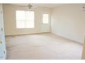 Bright living room features neutral carpet, a ceiling fan, and a door leading to outdoor space at 207 Mill St # A/B, Creedmoor, NC 27522
