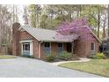 Brick home featuring a beautiful tree and a driveway leading to the side of the house at 212 Blueridge Rd, Carrboro, NC 27510