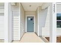 Close-up of the entryway with a light blue front door and white siding, pillars, and trim at 2207 Cherry Creek Rd, Haw River, NC 27258