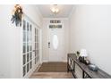 Bright foyer features hardwood floors, a console table, and glass paned doors at 235 Mallard Loop Dr, Clayton, NC 27527