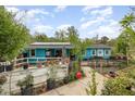 Charming blue house featuring solar panels and a lovely landscaped garden with potted plants and a cozy deck at 2801 Bethune Dr, Raleigh, NC 27603