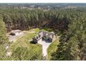 Expansive aerial view of the home, garage and surrounding land surrounded by dense, mature trees at 3220 Brassfield Rd, Creedmoor, NC 27522