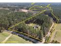 Expansive aerial view of a secluded home surrounded by lush forest and bordered by an estimated property line at 3220 Brassfield Rd, Creedmoor, NC 27522