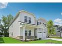 Beautiful two-story home with a covered porch, two-car garage, and a well-maintained lawn on a sunny day at 3849 Rosebush Dr, Zebulon, NC 27597