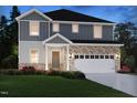 Charming two-story home with gray siding, brick accents, white trim, and attached garage at 3857 Rosebush Dr, Zebulon, NC 27597