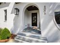 Inviting front porch with stone steps and an arched entry featuring a dark wood door at 5004 Lakemont Dr, Raleigh, NC 27609