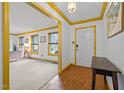 Welcoming entryway with hardwood floors, white walls with gold trim, and a view into the living room at 5130 Guess Rd, Durham, NC 27712