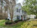 Charming two-story home with manicured landscaping, light-blue siding, and striking blue shutters at 7 S Indiancreek Pl, Durham, NC 27703