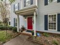 Inviting front porch with red door, blue shutters, and manicured landscaping at 7 S Indiancreek Pl, Durham, NC 27703