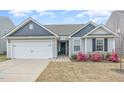 Charming single Gathering home showcasing a manicured lawn and attached two car garage at 733 Frosty Way, Zebulon, NC 27597
