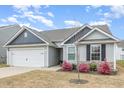 Charming single Gathering home showcasing a manicured lawn and attached two car garage at 733 Frosty Way, Zebulon, NC 27597