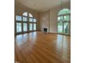 Spacious living room with a fireplace, large windows offering lake views, and gleaming hardwood floors at 737 Crabtree Crossing Pkwy, Cary, NC 27513