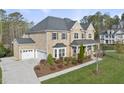 Beautiful brick home with a three-car garage, lush landscaping, and covered front porch at 8117 Fergus Ct, Wake Forest, NC 27587