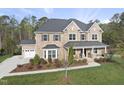 Striking brick home boasts a three-car garage, covered front porch, and meticulously landscaped grounds at 8117 Fergus Ct, Wake Forest, NC 27587