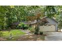 Ranch home featuring a stone facade, attached garage and mature landscaping at 8805 Leesville Rd, Raleigh, NC 27613