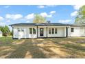 Front view of a beautiful white home featuring a modern front door and manicured lawn at 8917 Fowler Rd, Zebulon, NC 27597