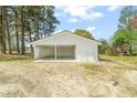 Exterior view of a detached two-car garage with white siding and concrete floor at 8917 Fowler Rd, Zebulon, NC 27597