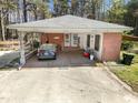 View of the carport featuring a brick facade, covered parking, and a 'welcome' sign at 906 Perry Rd, Zebulon, NC 27597