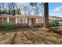 Charming single-story brick house featuring a covered carport and mature trees in a spacious front yard at 906 Perry Rd, Zebulon, NC 27597