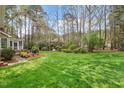 Lush green backyard with mature trees and attractive landscaping at 105 Fifemoor Ct, Cary, NC 27518